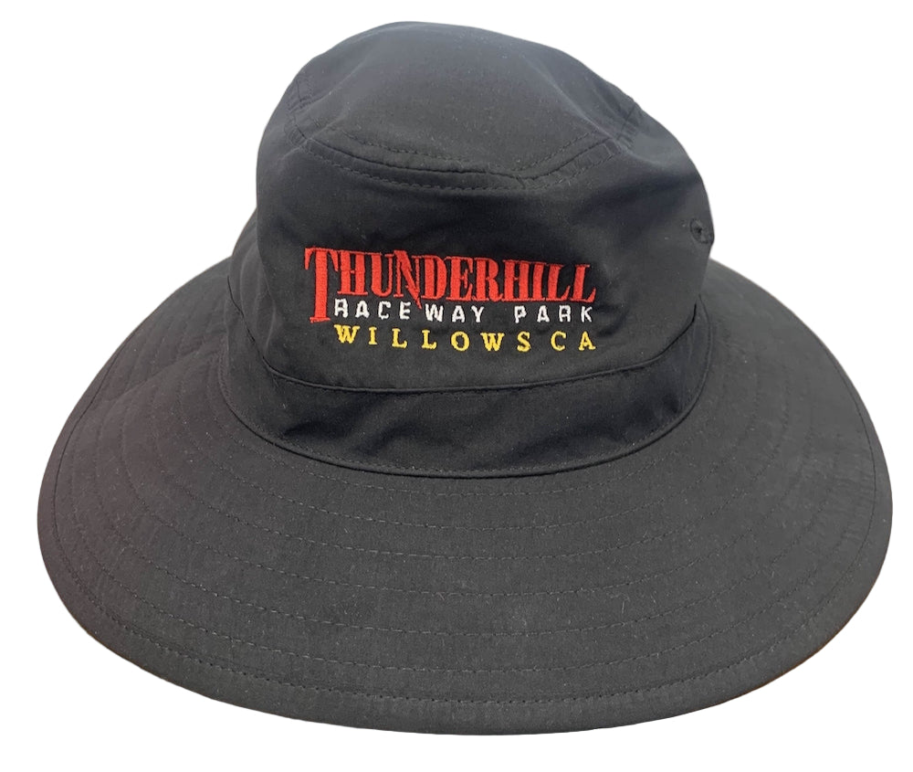 Black bucket hat with 'Thunderhill Raceway Park Willowsca' text on a wooden surface