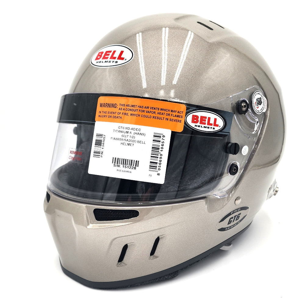 Close-up of Bell GT6 RD 4C/EC helmet in titanium finish with barcode label and SNELL/FIA certifications